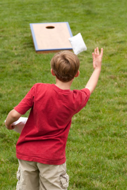 Boy playing cornhole